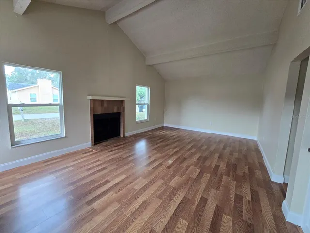 wooden floor fireplace and windows in an empty room