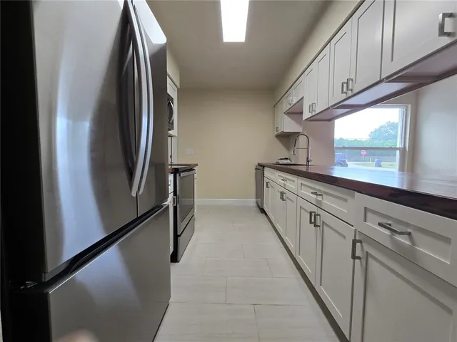 a view of a kitchen with stainless steel appliances granite countertop cabinets and a window