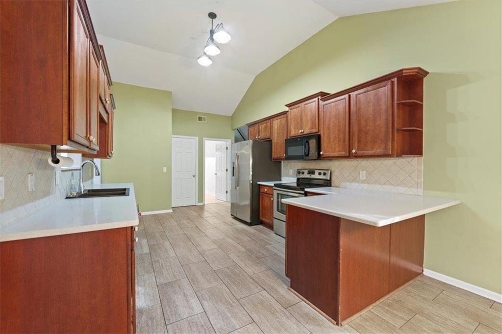1218 Morgans Run Monroe, GA 30656 - Photo 7 of 39 a kitchen with stainless steel appliances granite countertop a sink stove and refrigerator