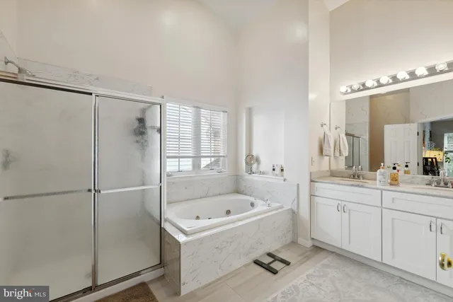 a bathroom with a tub sink shower and mirror