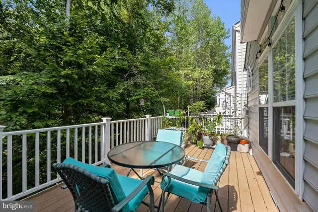a balcony with wooden floor table and chairs