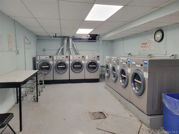 a utility room with dryer washer and a view of living room