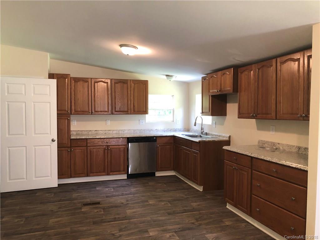 1785 Doe Court Iron Station, NC 28080 - Photo 5 of 14 a kitchen with stainless steel appliances granite countertop wooden cabinets a stove top oven a sink and dishwasher