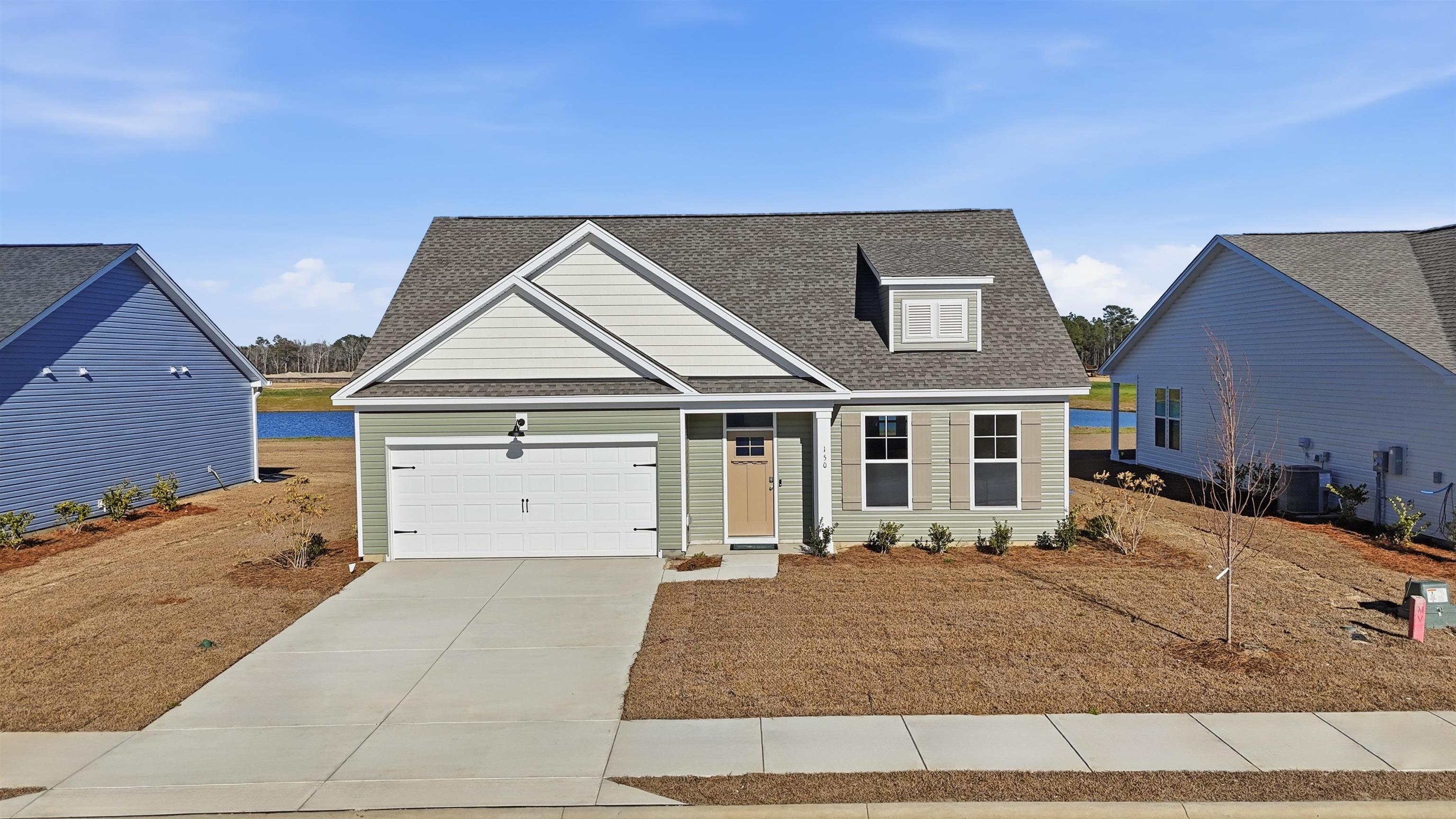 View of front facade featuring a shingled roof, driveway, and an attached garage