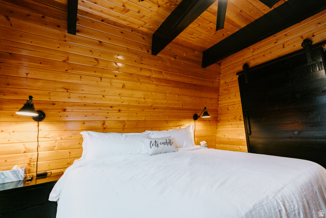 1413 Basel Drive Midway, UT 84049 - Photo 81 of 137 Bedroom featuring wood walls, a wooden ceiling with exposed beams, and a barn door