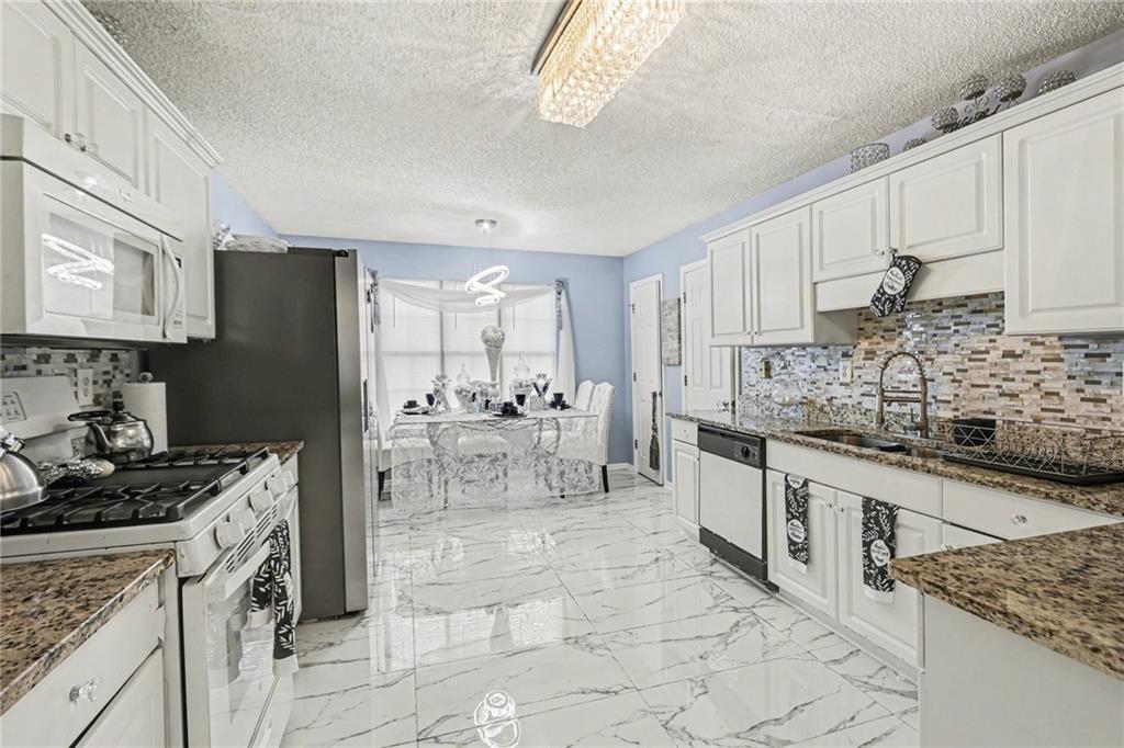 60 Post Oak Trace Villa Rica, GA 30180 - Photo 11 of 34 a kitchen with stainless steel appliances granite countertop a stove top oven a sink a refrigerator and cabinets