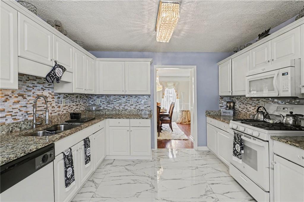 60 Post Oak Trace Villa Rica, GA 30180 - Photo 13 of 34 a kitchen with granite countertop white cabinets and white appliances