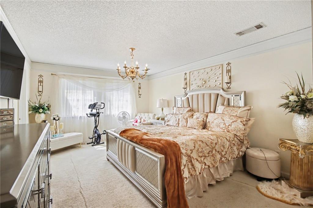 60 Post Oak Trace Villa Rica, GA 30180 - Photo 22 of 34 a bedroom with a bed and a chandelier