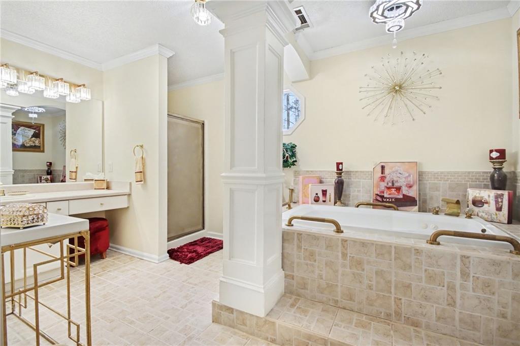 60 Post Oak Trace Villa Rica, GA 30180 - Photo 25 of 34 a bedroom with a bed dresser and a chandelier