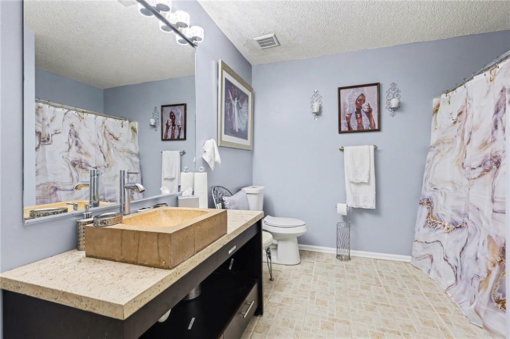 60 Post Oak Trace Villa Rica, GA 30180 - Photo 28 of 34 a bathroom with a sink a toilet and a shower curtain