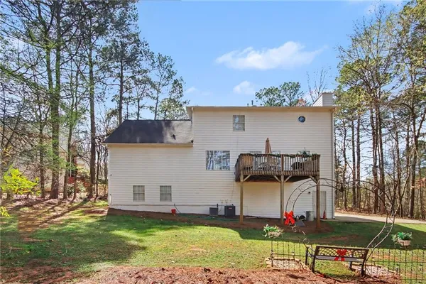 a view of a house with backyard and a tree