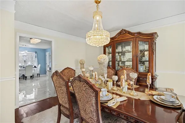 a view of a dining room with furniture a chandelier and wooden floor