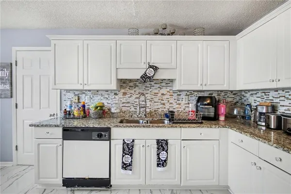 a kitchen with stainless steel appliances granite countertop a sink and cabinets