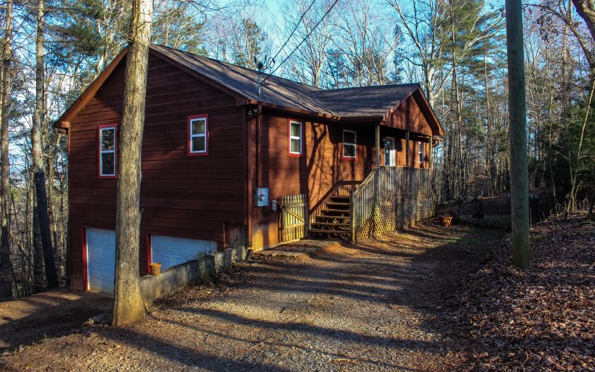 810 Riverview Drive Ellijay, GA 30540 - Photo 1 of 1 a view of wooden house with a small yard plants and large tree