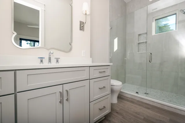 a bathroom with a double vanity sink toilet and shower