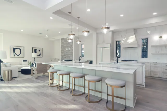 a large kitchen with a large counter top space appliances and a chandelier