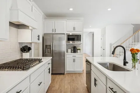 a kitchen with white cabinets and stainless steel appliances