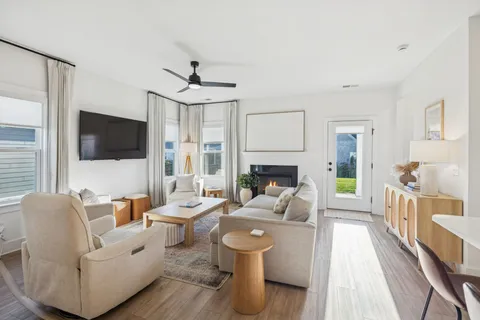 a living room with furniture a flat screen tv and a fireplace