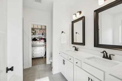 a en suite bathroom with double vanity and a mirror
