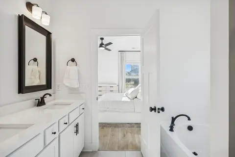 a bathroom with a double vanity sink mirror and bathtub