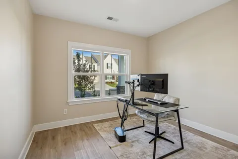 a view of workspace with wooden floor windows