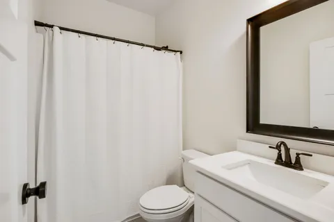 a bathroom with a sink vanity mirror and toilet