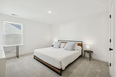 a bed sitting in a bedroom next to a window