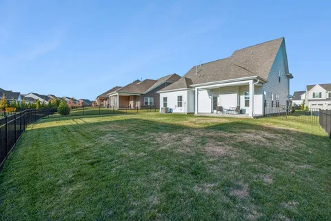 a front view of a house with a garden and trees