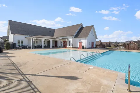 a view of a house with a yard and table chairs