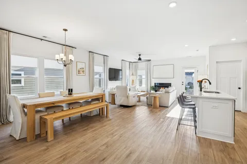 a living room with furniture appliances and wooden floor
