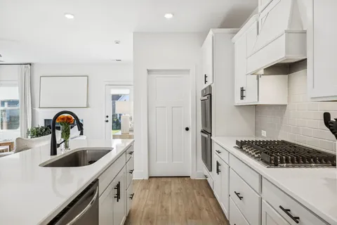 a kitchen with a sink a stove and cabinets