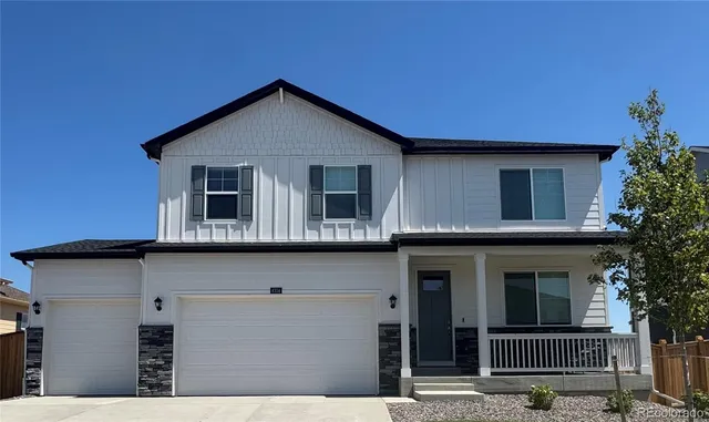 a front view of a house with a tree