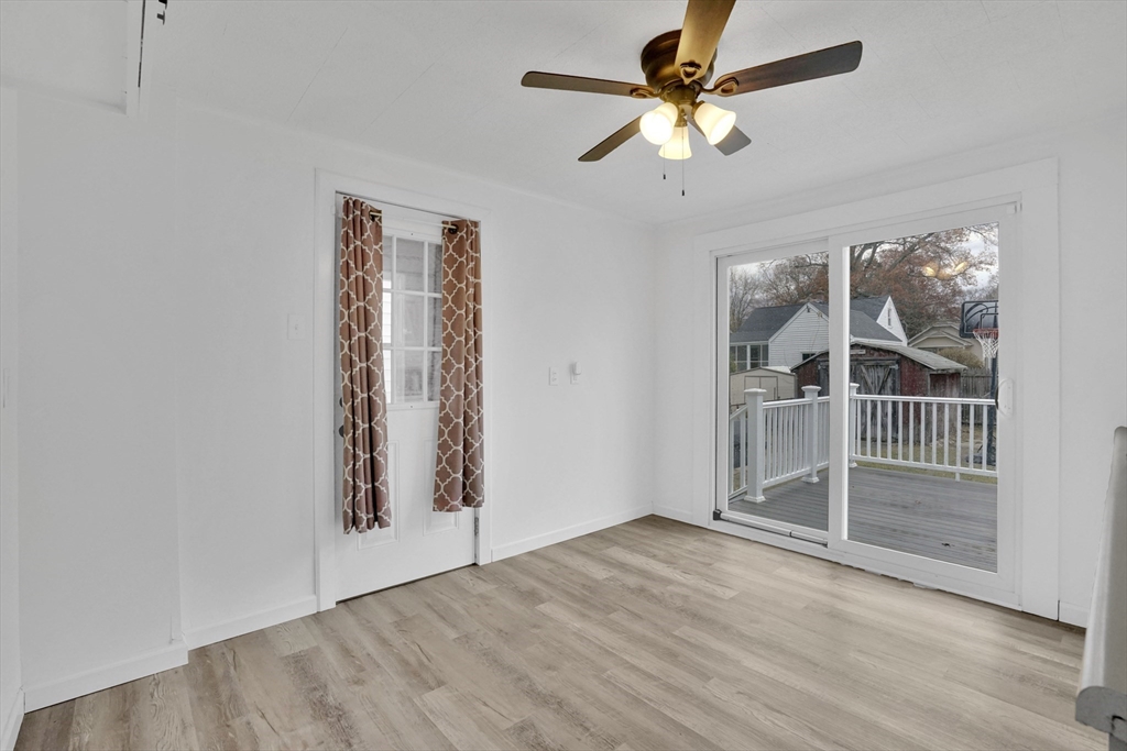 155 Powell Avenue Springfield, MA 01118 - Photo 5 of 41 an empty room with wooden floor and a ceiling fan