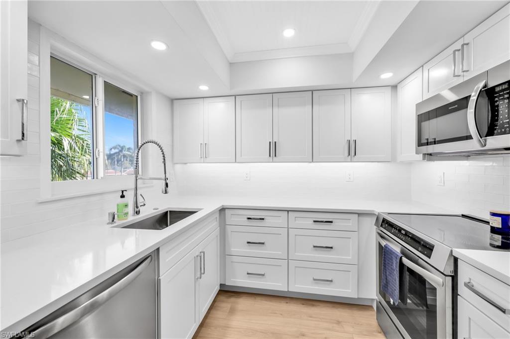 a kitchen with granite countertop a sink stainless steel appliances and cabinets