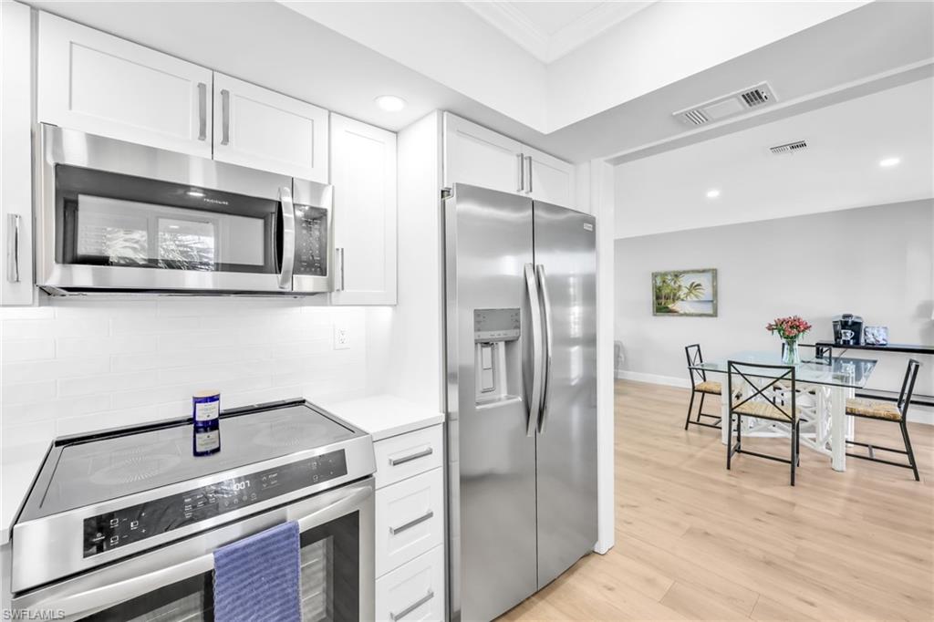 138 Teryl Road, Unit 42 Naples, FL 34112 - Photo 2 of 34 a kitchen with stainless steel appliances granite countertop a refrigerator and a stove top oven