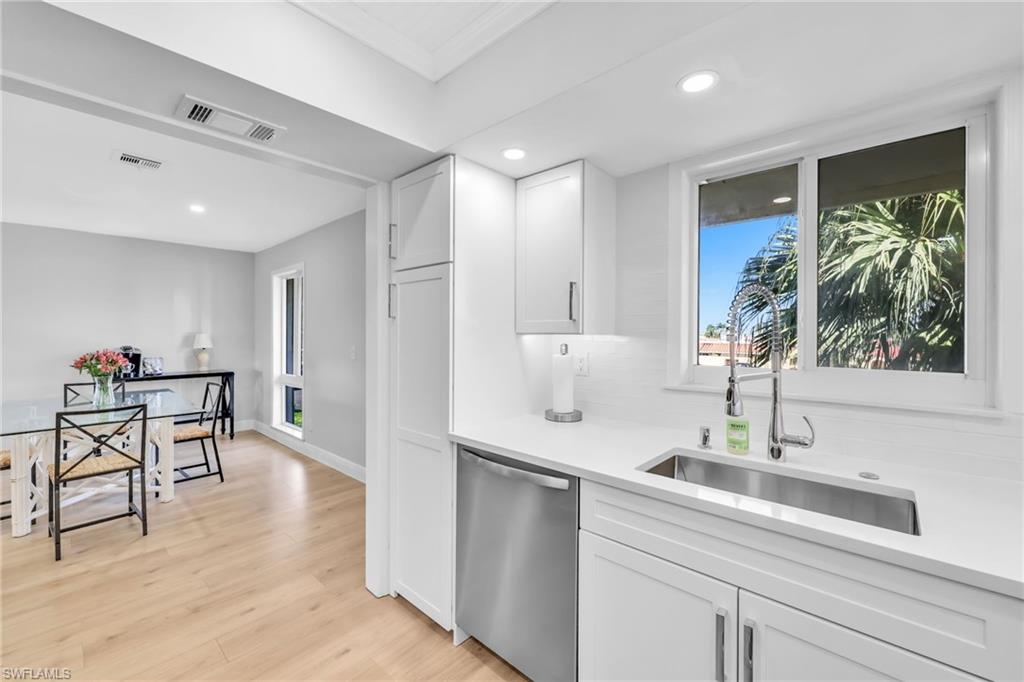 138 Teryl Road, Unit 42 Naples, FL 34112 - Photo 3 of 34 a kitchen with stainless steel appliances kitchen island a table and chairs in it