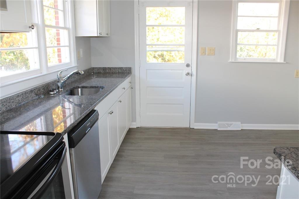 4322 Tillman Road Charlotte, NC 28208 - Photo 7 of 20 a kitchen with granite countertop a sink window and cabinets