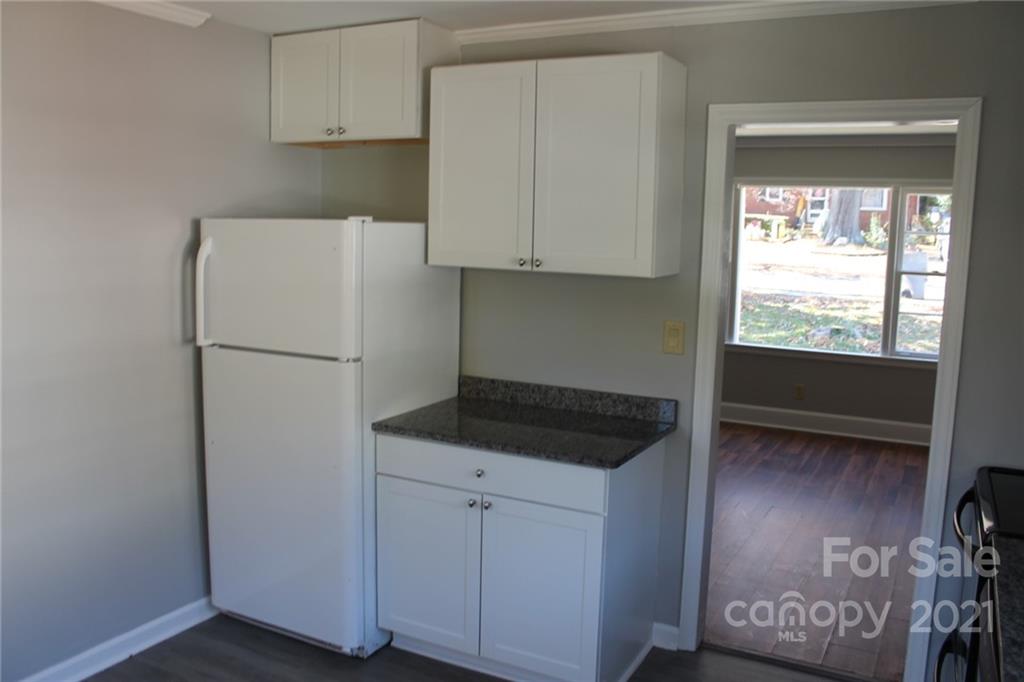 4322 Tillman Road Charlotte, NC 28208 - Photo 9 of 20 a kitchen with a refrigerator and white cabinets