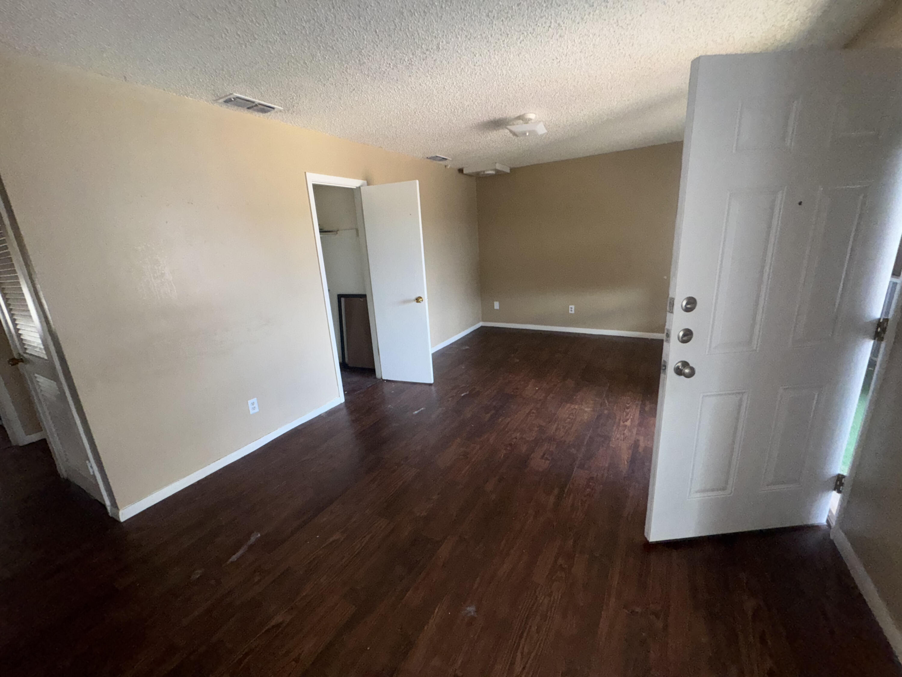 100 Pecos Place Plainview, TX 79072 - Photo 12 of 28 an empty room with wooden floor and entrance