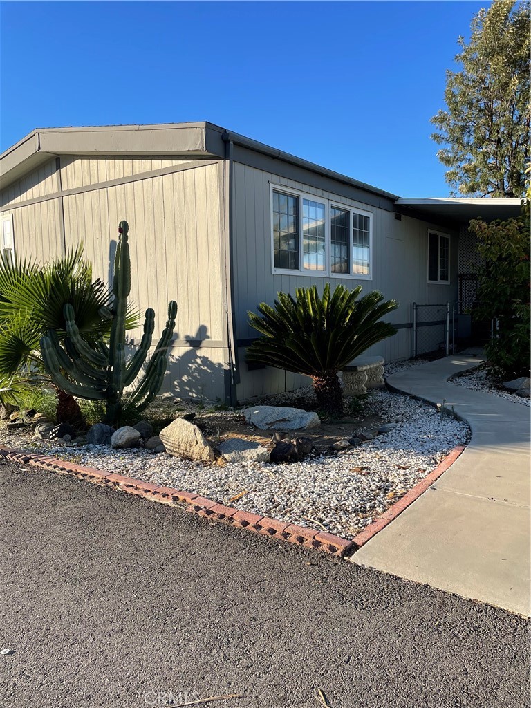 15181 Van Buren Boulevard, Unit 99 Riverside, CA 92504 - Photo 2 of 12 a view of a house with backyard and plants