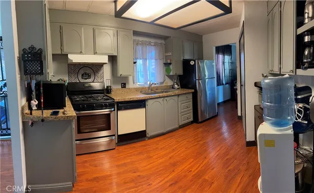 a kitchen with stainless steel appliances a stove a sink and a refrigerator