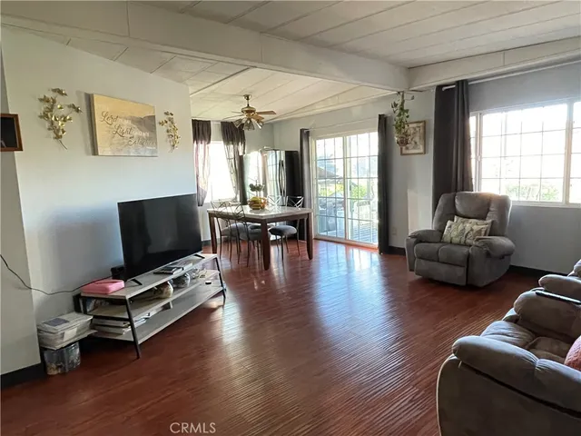 a living room with furniture flat screen tv and wooden floor
