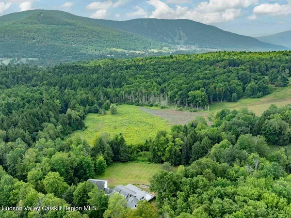 a living room with furniture a flat screen tv and a floor to ceiling window