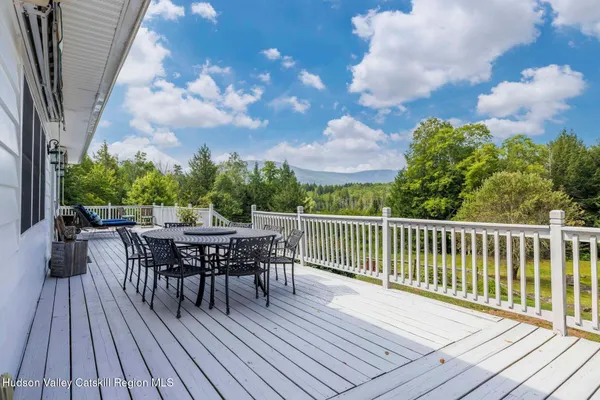 a living room with furniture a flat screen tv and a floor to ceiling window