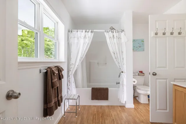 a bedroom with a bed and a flat tv screen next to a window