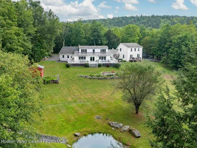 a view of a dining room with furniture a chandelier and large windows