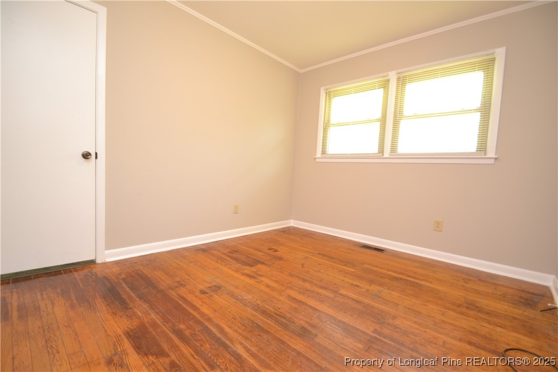 717 Friar Tuck Road Raleigh, NC 27610 - Photo 13 of 31 an empty room with wooden floor and windows