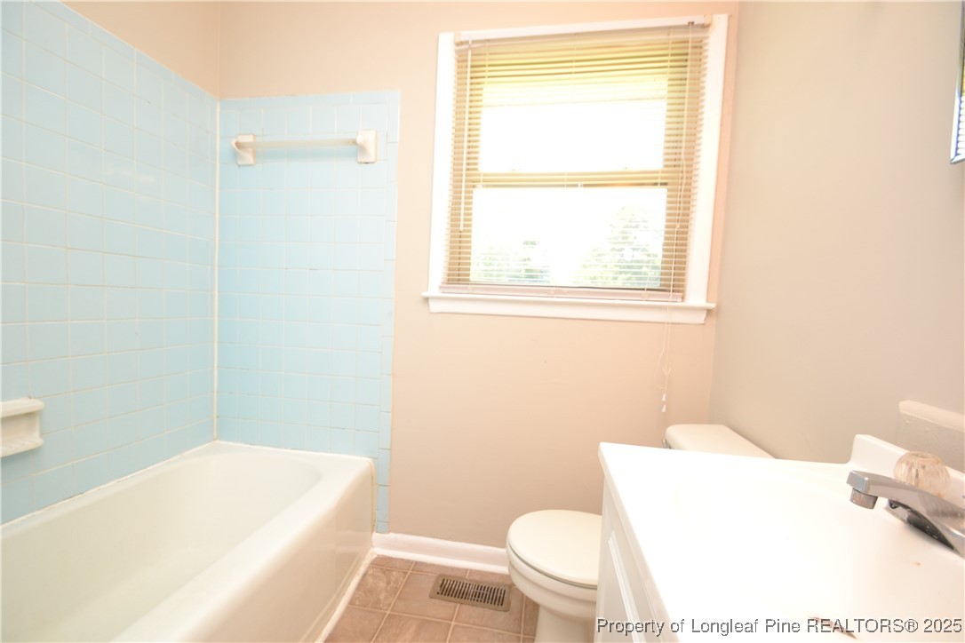 717 Friar Tuck Road Raleigh, NC 27610 - Photo 17 of 31 a bathroom with a toilet a sink and a bathtub