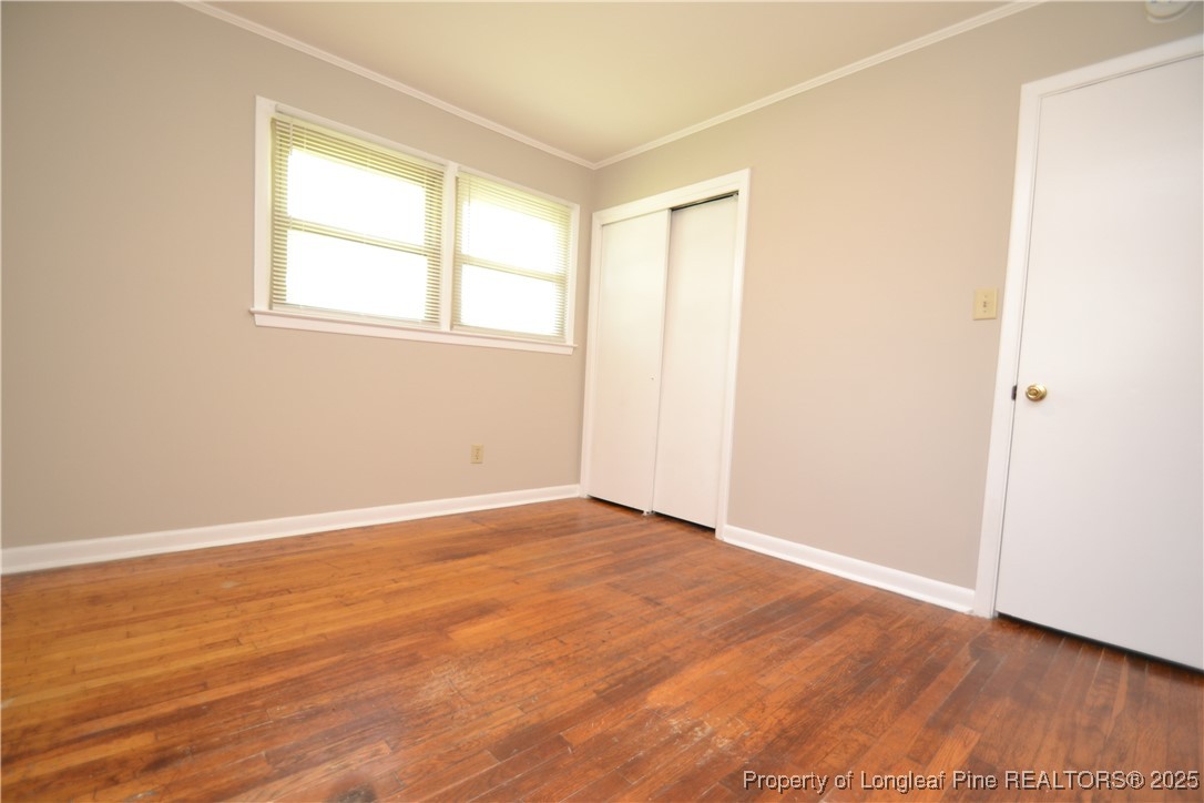 717 Friar Tuck Road Raleigh, NC 27610 - Photo 19 of 31 an empty room with wooden floor and windows