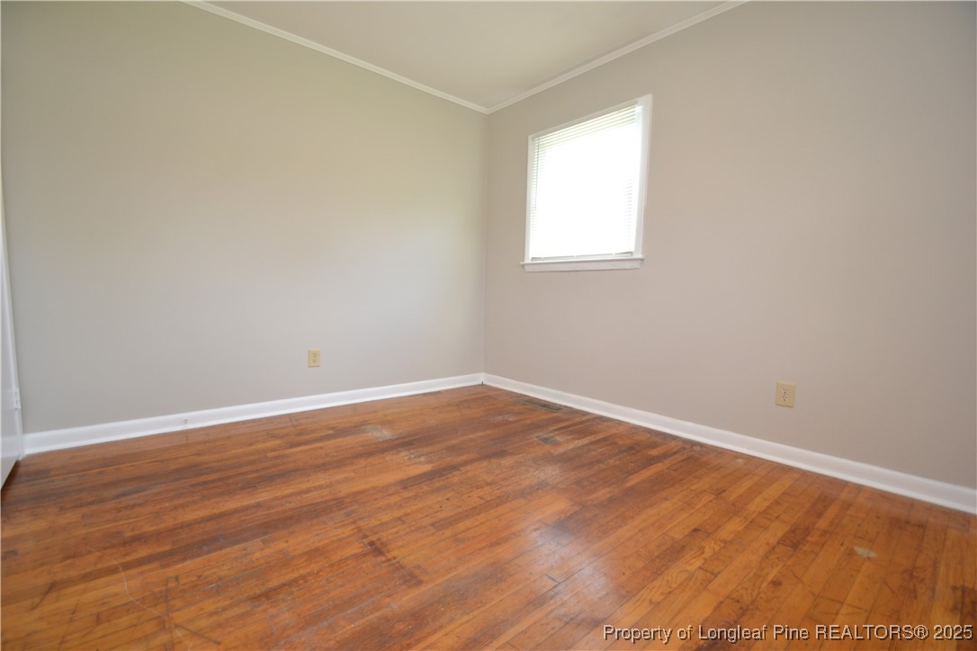 717 Friar Tuck Road Raleigh, NC 27610 - Photo 21 of 31 an empty room with wooden floor and windows